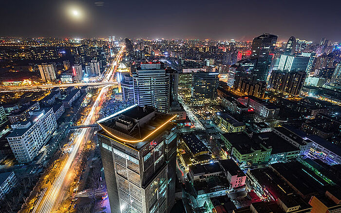 Beijing skyline at night with illuminated skyscrapers.