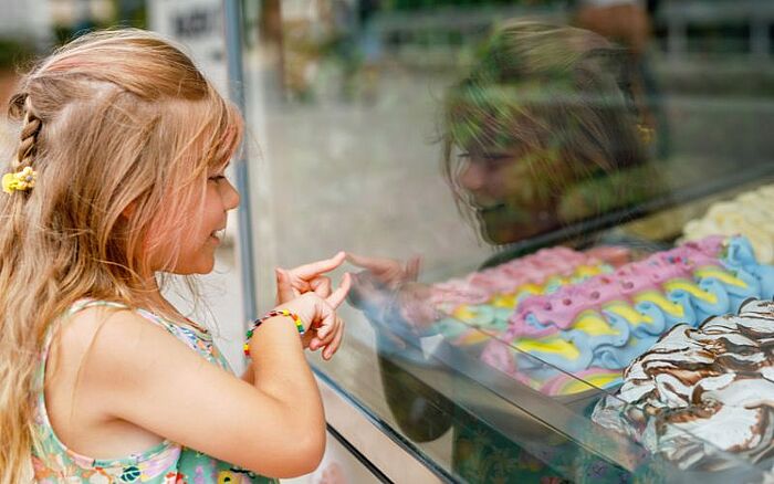 Happy girl choosing ice cream from outdoor stand