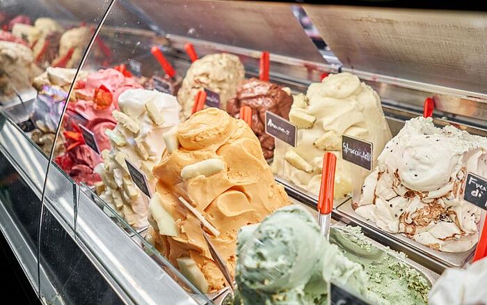 Gelato with fruit and different flavors in ice cream stand