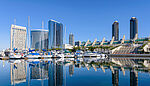 Panoramic morning view of San Diego Marina, with yachts docked along the bay and modern high-rise buildings in the Marina District of downtown San Diego, California.