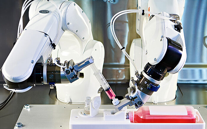 Close-up of a medical robot with mechanical arms in a clinical setting, designed for precision procedures or surgeries.