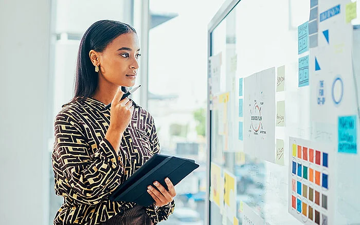 Woman reviewing sticky notes to review her trademark filing strategy. 