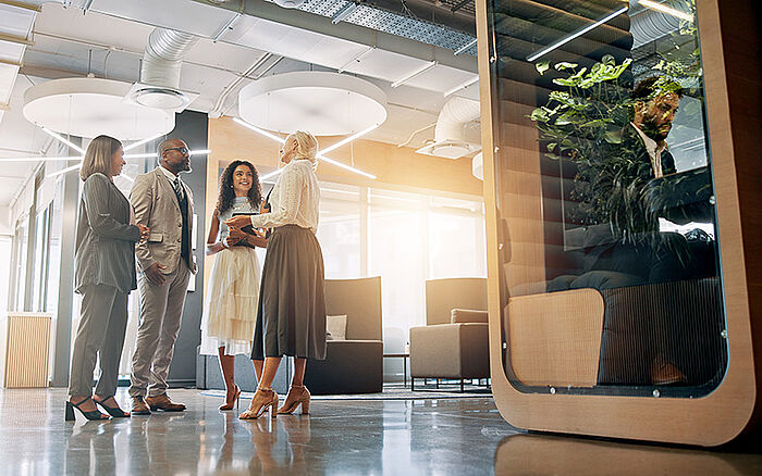Business people talking in a bright lobby.