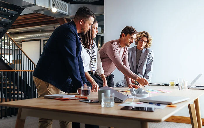 Team of professionals gathered around a table, actively discussing business ideas.