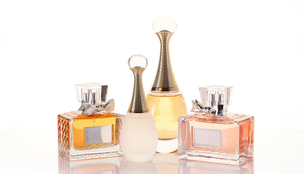 A collection of elegant perfume bottles arranged aesthetically on a reflective surface, highlighting luxury and personal style.